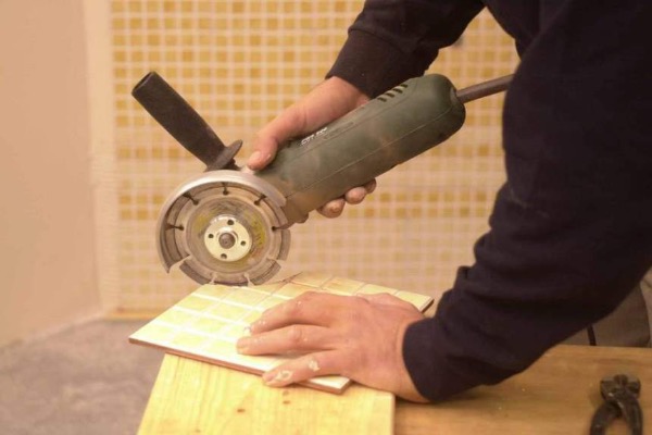 мужчина режет плитку сегментным алмазным диском
